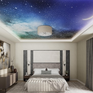 May include: A bedroom with a white ceiling featuring a printed design of a starry night sky. The room has a large bed with a gray headboard and white bedding. There is a light fixture in the center of the ceiling.