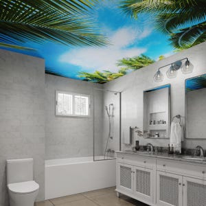 May include: A white bathroom with a bathtub, toilet, and double vanity with a white countertop. The ceiling has a tropical sky mural with palm trees.