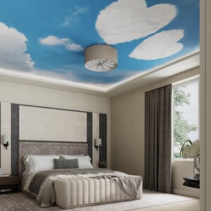 May include: A bedroom with a white ceiling painted to look like a blue sky with white clouds. A ceiling fan with a brown shade hangs from the ceiling. The bed has a white headboard and a white comforter. There is a gray rug on the floor.