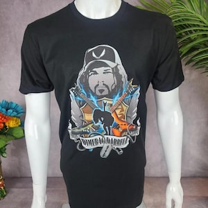 May include: Black t-shirt with a graphic print of Dimebag Darrell, a musician, holding two electric guitars. The graphic includes the text "Dimebag Darrell".
