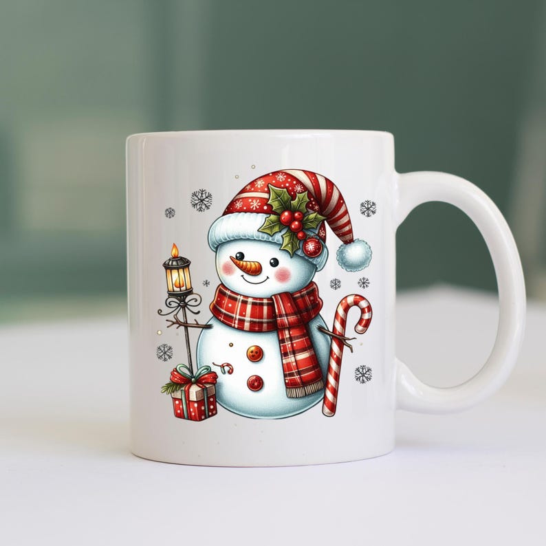 May include: White ceramic mug with a snowman design. The snowman is wearing a red and white hat with holly and berries, a red and black plaid scarf, and holding a candy cane. The snowman is also holding a lantern with a lit candle.