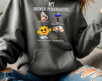 May include: A gray hoodie with the text "My Brewed Personalities" and four illustrations of coffee drinks with funny faces and descriptions: "Perky Cappuccino", "Chilled-out Cold Brew", "Early Sunrise Espresso", and "Philosophical Press".
