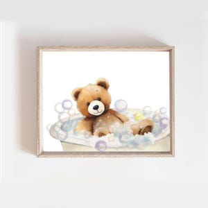 May include: A brown teddy bear wearing a yellow rubber ducky is taking a bath in a white bathtub surrounded by colorful bubbles.