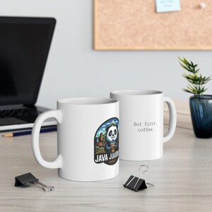 Pode incluir: Duas canecas de cerâmica branca com um design de urso panda. Uma caneca diz "But first, coffee." A outra caneca diz "Java Journey" com um urso panda segurando uma xícara de café.