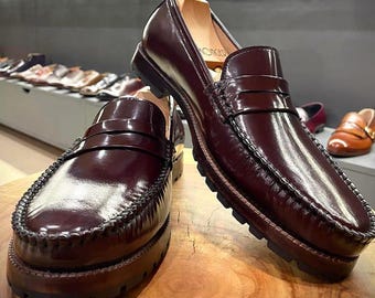 Burgunderrote, glänzende Penny-Loafer mit Mokassin-Zehenkappe, Beefroll-Detail, klassischer Schlitz, klobige Sohle