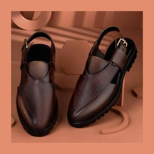May include: A pair of dark brown leather sandals featuring a textured finish, a closed-toe design with side cutouts, and an adjustable ankle strap with a gold-toned metal buckle. The footwear includes a thick black sole with a treaded bottom surface.