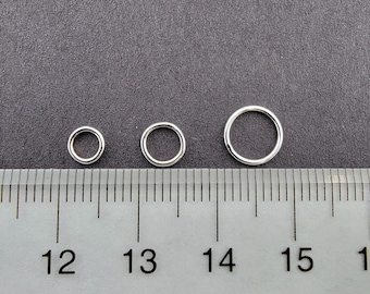 May include: Three silver jump rings of different sizes, measured against a ruler. The rings are 1/2 inch, 3/8 inch, and 1/4 inch in diameter.