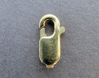 May include: A gold-toned metal clasp with a spring-loaded closure. The clasp has a small inscription that reads "GF".