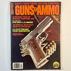 May include: A December 1977 issue of Guns & Ammo magazine featuring a silver semi-automatic pistol with a textured brown grip and a brown leather holster. The cover displays text including BATF'S OWN VIEWS ON GUN CONTROL and A POTENT PAIR OF SPECIAL PURPOSE .45s.