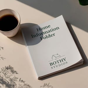 May include: A white Home Information Folder with the Bothy Studios logo and text, next to a cup of coffee. The folder is open, and the text "Home Information Folder" is visible. The scene is lit by natural light.