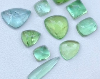 May include: Assortment of ten green and blue gemstones, cut and polished in various shapes, including square, oval, and teardrop.