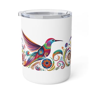 May include: White travel mug featuring a colorful hummingbird design. The hummingbird has a rainbow of colors, including red, blue, orange, and green. The design also includes floral and swirl patterns. The mug has a clear lid.