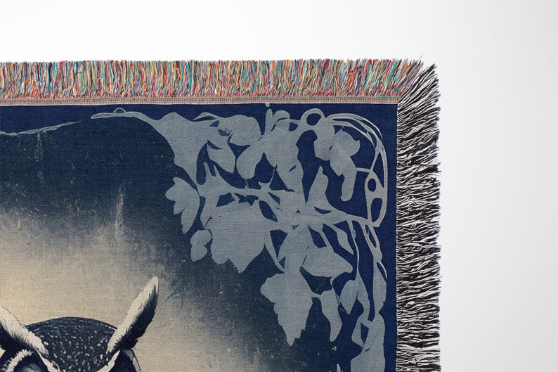 May include: A blue woven tapestry with a white owl design and a floral pattern in the corner. The tapestry has a fringe border.