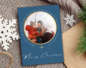 May include: A blue Christmas card with a gold circle around a photo of a family. The text on the card reads "When they saw the star, they rejoiced with exceeding great joy. Matthew 2:10" and "Merry Christmas".