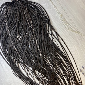 May include: A long set of black braids with silver and blue charms attached.