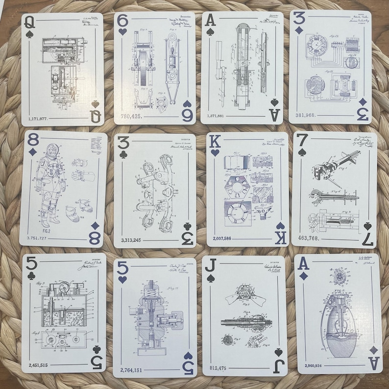 May include: A deck of playing cards with a unique design. Each card features a blueprint-style engineering drawing in blue and white. The cards display various mechanical designs, including gears, engines, and other machine components. The suits are represented by traditional symbols, and the card values are visible.