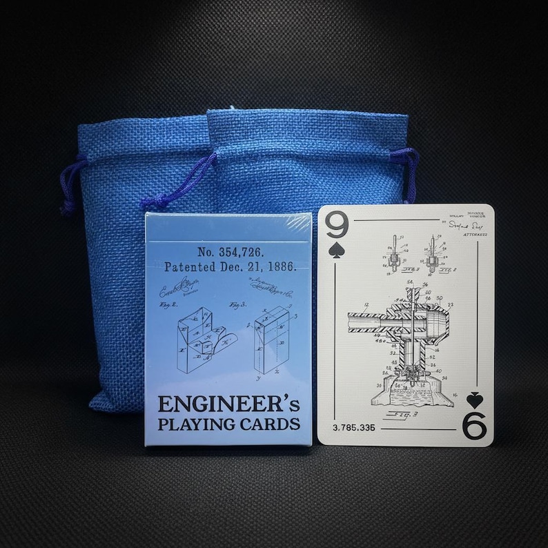 May include: A deck of "Engineer's Playing Cards" with a blue box and a blue drawstring bag. The card shows a patent illustration and the number 9 of spades and 6 of hearts. The box reads "No. 354,726. Patented Dec. 21, 1886."