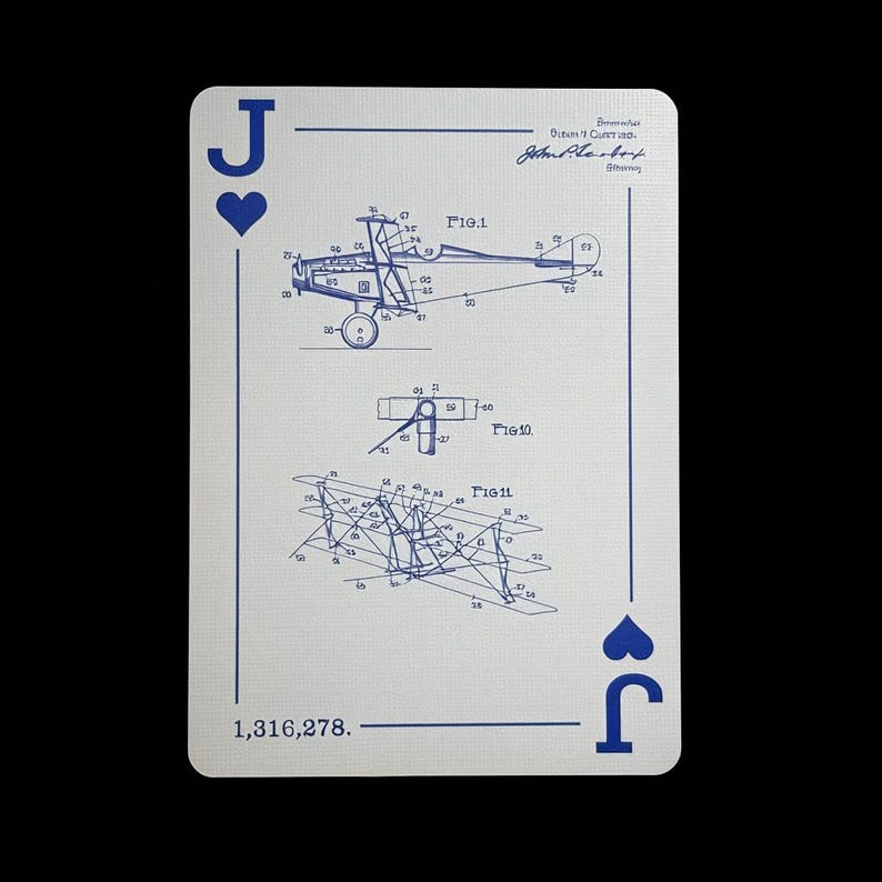 May include: A playing card featuring the Jack of Hearts. The card has a white background with blue ink illustrations of an airplane blueprint. The top right corner has a signature and text. The bottom left corner has the number 1,316,278.