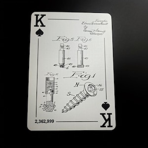 May include: A playing card featuring a black and white technical drawing of a screw and other mechanical components. The card is marked with the King of Spades symbol and the number 2,362,999. The card also includes the name of the inventor.