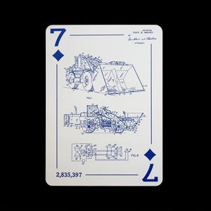 May include: Playing card featuring a blue diagram of a front-end loader on a white background. The card is a seven of diamonds, with the number 7 and a diamond symbol in the corners. The card also has the patent number 2,835,397.