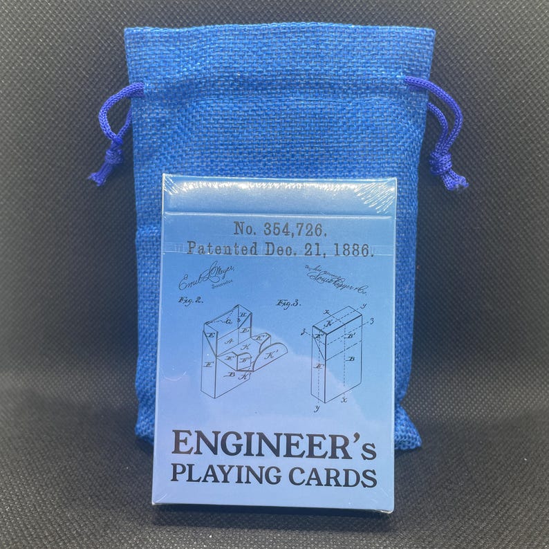 Unopened deck of cards resting in front of a blue drawstring baggy.