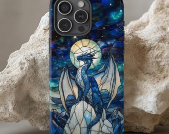 May include: A blue and white stained glass phone case with a dragon design. The dragon is perched on a rock with its wings spread out. The background is a dark blue with stars.