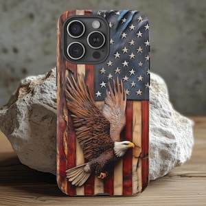 May include: A phone case featuring a carved American flag design with a soaring bald eagle. The case has a distressed wood-like texture with red and white stripes, a blue field of stars, and a detailed eagle in shades of brown and white.