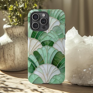 May include: A green and white phone case with a geometric pattern. The case has a cutout for the camera lens.