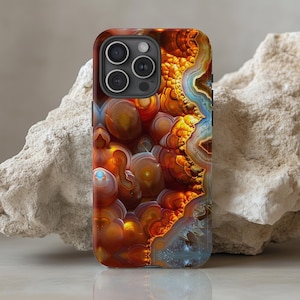 May include: A phone case with a colorful agate pattern. The case has a black camera bump with three lenses. The agate pattern is a mix of orange, red, blue, and white.