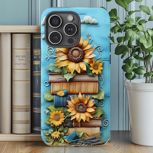 May include: A blue phone case featuring a design of sunflowers, books, and small blue birds. The sunflowers are yellow and brown, with green leaves. The books are stacked, and the background is a light blue with white clouds.