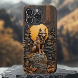 May include: A wood-carved phone case with a wolf design. The wolf is sitting on a rock in front of a full moon. The case is made of dark wood with a brown and black wolf design.