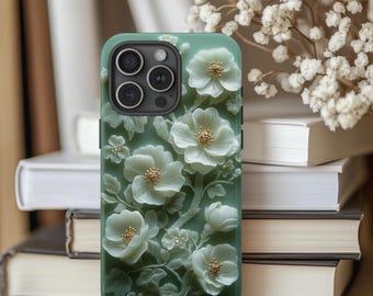 May include: A green phone case with a white floral design. The flowers are carved and have a 3D effect. The phone case is for an iPhone 13 Pro Max.
