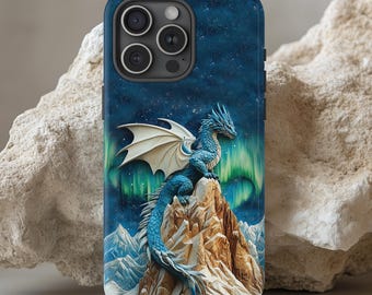 May include: A blue and white dragon with wings perched on a mountain peak. The dragon is set against a dark blue background with green and blue aurora borealis lights. This design is printed on a black iPhone case.