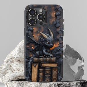 May include: Black phone case featuring a detailed dragon design. The dragon is perched on a stack of books, with a starry sky background. The case has a textured appearance and a dark color palette.