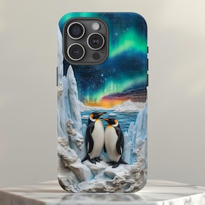 Könnte beinhalten: Handyhülle mit einer farbenfrohen Illustration von zwei Pinguinen in einer Schneelandschaft unter Nordlichtern. Die Hülle hat eine glänzende Oberfläche und einen Kameraausschnitt. Die Pinguine sind schwarz-weiß mit gelben Akzenten.