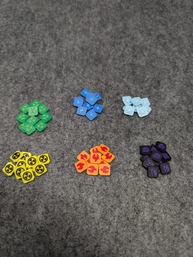 May include: Six piles of colorful game tokens. Each pile has a different symbol: a skull and crossbones, a lightning bolt, a snowflake, a radiation symbol, a flame, and a purple symbol.