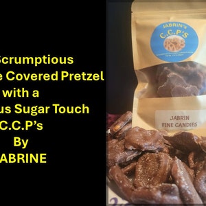 Puede incluir: Una bolsa de pretzels cubiertos de chocolate con un glaseado de azúcar. La bolsa está etiquetada con "JABRIN'S C.C.P's" y "JABRIN FINE CANDIES".
