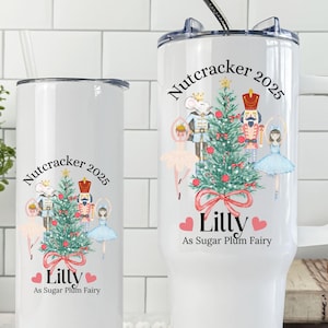 May include: Two white insulated tumblers with a Nutcracker theme. One has a handle. Both feature a Christmas tree, ballet dancers, and the text "Nutcracker 2025" and "Lilly As Sugar Plum Fairy".