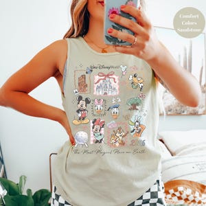 May include: A light green tank top featuring a collage of Disney characters and landmarks. The design includes Mickey Mouse, Minnie Mouse, Donald Duck, and Chip and Dale, with the text "Walt Disney World" and "The Most Magical Place on Earth".
