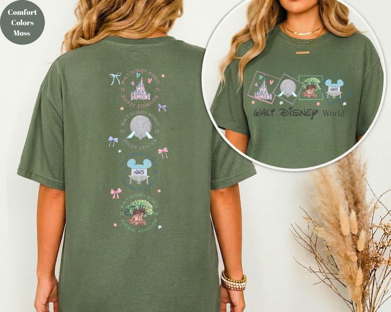 May include: Moss green t-shirt with a Walt Disney World graphic. The front features the text "Walt Disney World" and four small illustrations. The back has a vertical design with castle, Spaceship Earth, Mickey Mouse, and Animal Kingdom graphics.