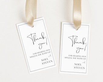 May include: Two white thank you tags with black text and a gold ribbon. The text reads "Thank you!" and "For sharing our special day with us!" followed by the names "Noel and Steven".