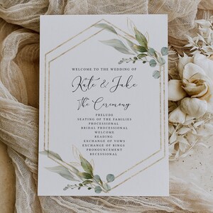 Peut inclure: Un programme de c&eacute;r&eacute;monie de mariage avec un cadre g&eacute;om&eacute;trique dor&eacute; et des feuilles vertes en aquarelle. Le programme liste l'ordre des &eacute;v&eacute;nements, y compris le pr&eacute;lude, la mise en place des familles, la procession, la procession nuptiale, l'accueil, la lecture, l'&eacute;change des v&oelig;ux, l'&eacute;change des alliances, la d&eacute;claration et la sortie des mari&eacute;s. Les noms du couple, "Kate & Jake", sont &eacute;crits en cursive en haut.