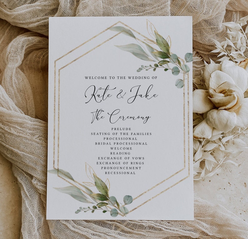 Peut inclure: Un programme de c&eacute;r&eacute;monie de mariage avec un cadre g&eacute;om&eacute;trique dor&eacute; et des feuilles vertes en aquarelle. Le programme liste l'ordre des &eacute;v&eacute;nements, y compris le pr&eacute;lude, la mise en place des familles, la procession, la procession nuptiale, l'accueil, la lecture, l'&eacute;change des v&oelig;ux, l'&eacute;change des alliances, la d&eacute;claration et la sortie des mari&eacute;s. Les noms du couple, "Kate & Jake", sont &eacute;crits en cursive en haut.
