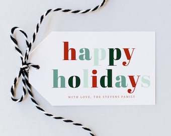 Peut inclure: Une étiquette cadeau blanche avec les mots "happy holidays" en lettres rouges, vertes et vert clair. L'étiquette est attachée avec de la ficelle noire et blanche. Le texte "WITH LOVE, THE STEVENS FAMILY" est imprimé en bas.