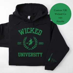 May include: Black hoodie with a green print that says "Wicked University" with a witch and a laurel wreath. The text "Est. 2003" is printed below the wreath. The word "Mia" is written in green on the right sleeve.