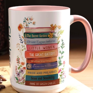 May include: White ceramic mug with a pink rim and handle. The mug features a stack of colourful books with titles such as "The Secret Garden", "Great Expectations", "Little Women", "The Great Gatsby", "Wuthering Heights", "Crime and Punishment", "Pride and Prejudice", "Sense and Sensibility", and "Anne of Green Gables".