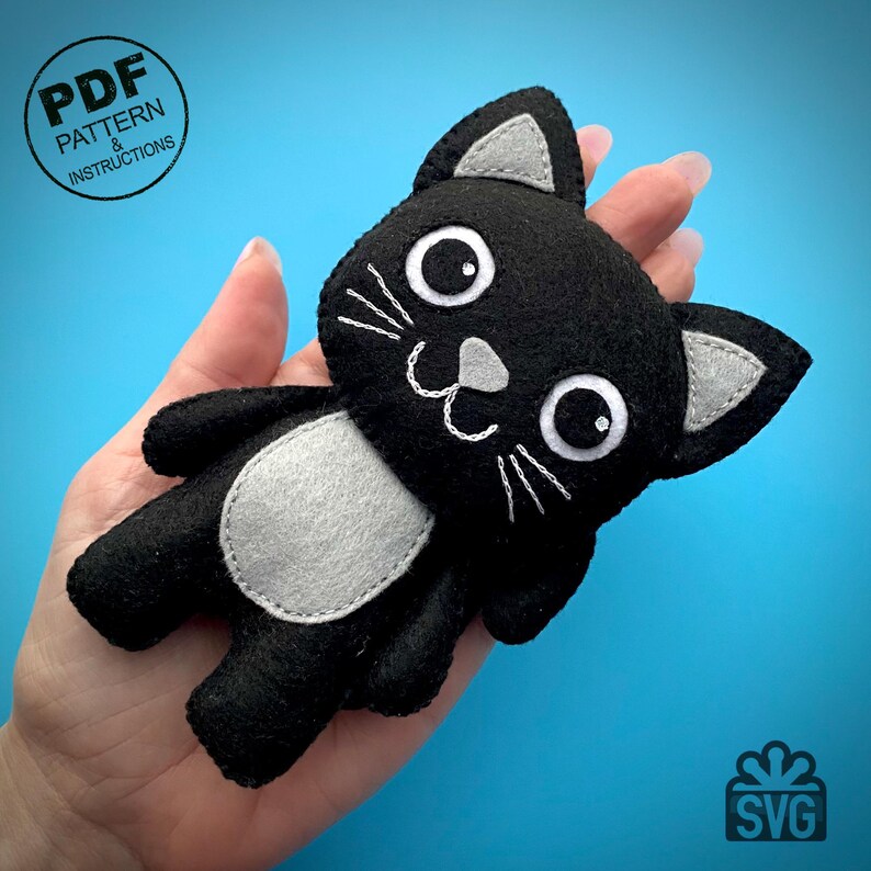 May include: A black felt cat plushie with white embroidered details and gray accents. The cat has large white eyes and a white belly patch. The image includes the text "PDF Pattern & Instructions" and "SVG".