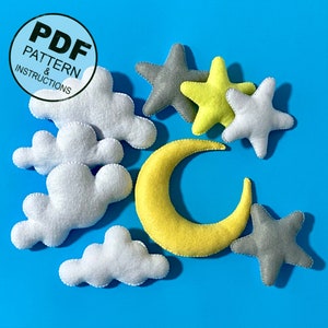 K&ouml;nnte beinhalten: Ein Set Filzspielzeug f&uuml;r ein Kinderzimmer oder eine Kindertagesst&auml;tte. Das Set enth&auml;lt einen gelben Halbmond, einen grauen Stern, einen gelben Stern, eine wei&szlig;e Wolke und eine graue Wolke. Die Spielzeuge sind alle weich und kuschelig und w&auml;ren perfekt f&uuml;r ein Baby oder Kleinkind.