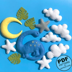 K&ouml;nnte beinhalten: Ein Set mit Filz-Applikationsvorlagen f&uuml;r einen Dinosaurier, Wolken, Sterne und Bl&auml;tter. Die Vorlagen sind im PDF-Format und beinhalten Anleitungen.