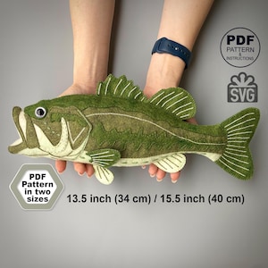 Può includere: Un pesce in feltro verde con dettagli cuciti bianchi, bocca aperta e un occhio scuro. Il testo recita: PDF PATTERN & INSTRUCTIONS, SVG, PDF Pattern in two sizes, 13.5 inch (34 cm) / 15.5 inch (40 cm).